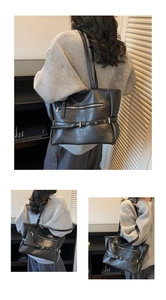 Close-up of black oversized tote bag with wrinkled texture and silver zipper details