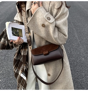 Macro shot of dark brown vintage crossbody bag with flap detail and ethnic strap
