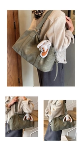 Detailansicht der olivgrünen Oversize-Ledertasche mit weicher Textur und Hasen-Anhänger