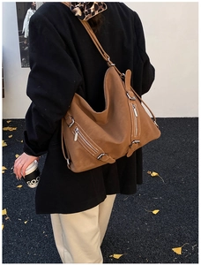Detail of vintage brown tote bag with metal zippers and adjustable shoulder straps