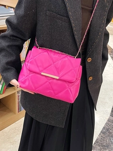 Pink quilted crossbody bag with gold chain strap worn by a model in a library setting