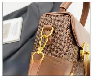 Detail of vintage woven shoulder bag with gold metal D-ring and spring buckle hardware