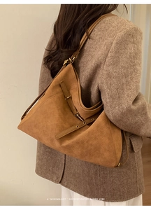 Detail of caramel frosted hobo bag with woven texture and adjustable metal buckle strap