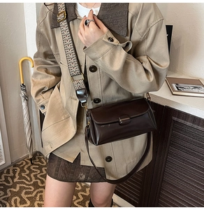 Detail of vintage crossbody bag with wide geometric woven strap and leather texture