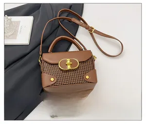 Detail view of mini brown crossbody bag with houndstooth texture and gold metal lock