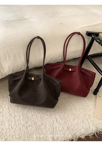 Detail of minimalist tote bags in dark coffee and wine red with gold metal buckle