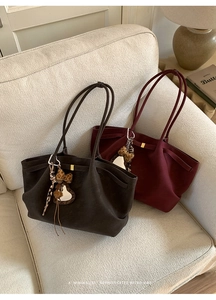 Close-up of vintage suede tote bags in dark brown and burgundy with leopard bow charms