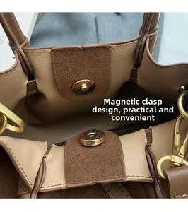 Close-up of magnetic buckle design and premium suede lining on a dark brown handbag