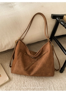 Detail of deep brown woven texture and decorative buckle on a retro tote bag
