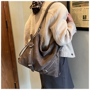 Detail of dark brown suede Hobo bag with side zipper and long shoulder strap
