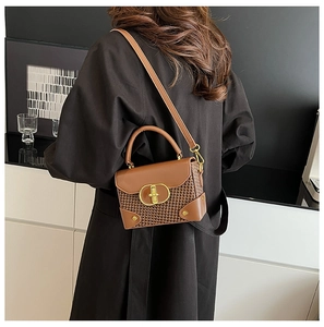 Detail view of brown leather woven crossbody bag with gold rotating lock and rivets