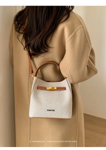 Close-up of contrast color bucket bag with woven texture and premium leather trim