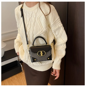 Detail of vintage crossbody bag with houndstooth fabric and gold ring clasp closure
