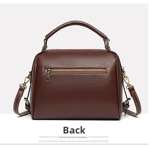Detailed back view of a dark brown soft leather handbag with golden zipper and white stitching