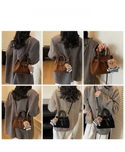 Detail shots of retro suede bucket bag with buckled straps and cute teddy bear charm