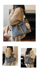 Detail of grey tote bag featuring woven texture and a cute plush bear charm accessory