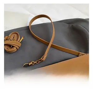 Detailaufnahme der braunen Lederhandtasche mit Metall-Drehverschluss und Kettenriemen