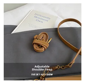 Details des verstellbaren braunen Leder-Schultergurts mit goldener Schnalle und Naht