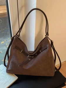 Vintage dark brown woven textured Hobo tote bag with gold hardware in soft natural lighting