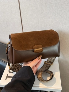 Minimalist dark brown crossbody bag with suede texture and geometric jacquard strap
