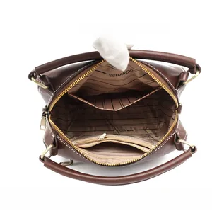 Interior view of brown leather handbag featuring multi-compartment lining and zipper pocket