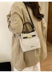 Detail of PANTOR bucket bag featuring canvas and black leather with gold twist lock