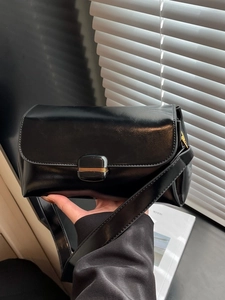 Minimalist black glossy crossbody bag with a gold decorative buckle for women's fashion