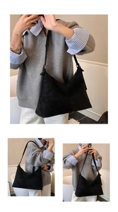 Detail view of large black faux suede hobo bag with diagonal stitching and wide strap