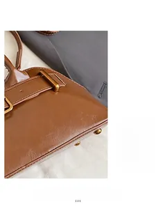 Close-up of brown polished leather texture and metallic buckle on handbag