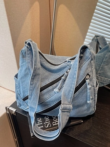 Retro light blue denim crossbody bag with diagonal zippers and adjustable wide strap