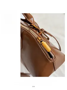 Detail of smooth gold zipper and glossy brown leather texture on a retro handbag