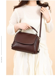 Detail of dark brown leather handbag with contrast stitching and vintage hardware