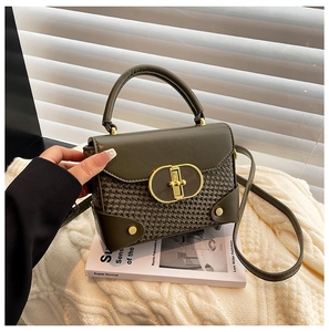 Close-up of olive green woven texture and golden twist lock on a retro small square bag