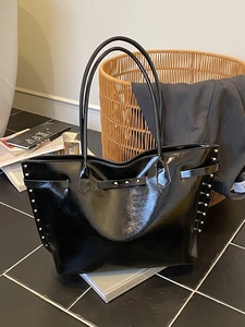 Large black glossy tote bag with silver studs and double shoulder straps for daily use