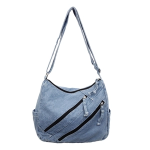 Light blue washed denim tote bag featuring triple front zippers and adjustable strap