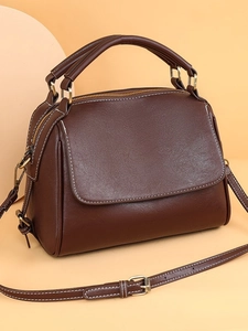 Dark brown leather handbag with contrast stitching and gold hardware in side view