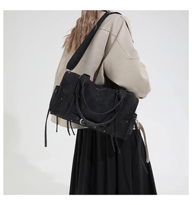 Détail du sac cabas noir mat avec des accents de franges et des boucles réglables