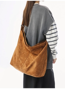 Vue détaillée d'un grand sac bandoulière en daim camel montrant le drapé et la texture