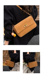 Nahaufnahme einer braunen Vintage-Umhängetasche mit Goldschnalle und Bommel-Anhänger
