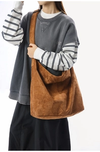 Sac Hobo marron en cuir mat porté par un mannequin montrant sa grande capacité et sa texture