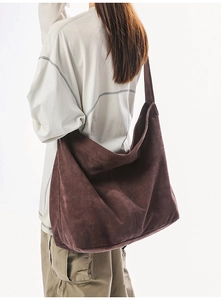 Détail d'un grand sac cabas marron foncé en matière brossée douce porté à l'épaule