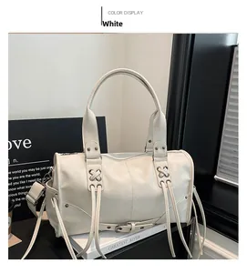 Détail du sac Boston en cuir blanc avec œillets métalliques et laçage croisé chic