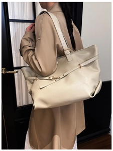 Dettaglio borsa shopper in pelle PU crema con finiture dorate su trench classico
