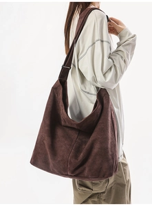Détail d'un grand sac bandoulière marron en toile délavée avec bandoulière large réglable
