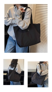 Détails d'un cabas noir minimaliste avec logo métallique et bandoulière en tissu