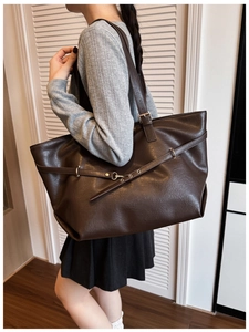 Dettaglio della borsa tote grande in pelle marrone scuro con fibbia in metallo