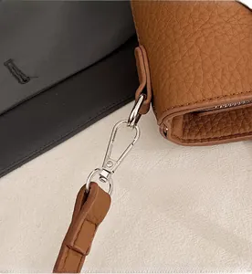 Detail of brown lychee grain texture with shiny silver detachable metal hook
