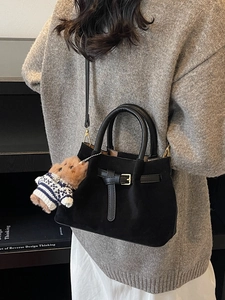 Retro black suede bucket bag with gold hardware and a cute teddy bear charm