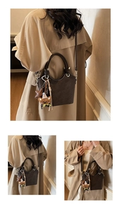 Detail of dark brown vintage bag with wavy edge and cute teddy bear plush pendant
