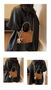 Detail of brown matte leather bucket bag with knot design and plush bear charm